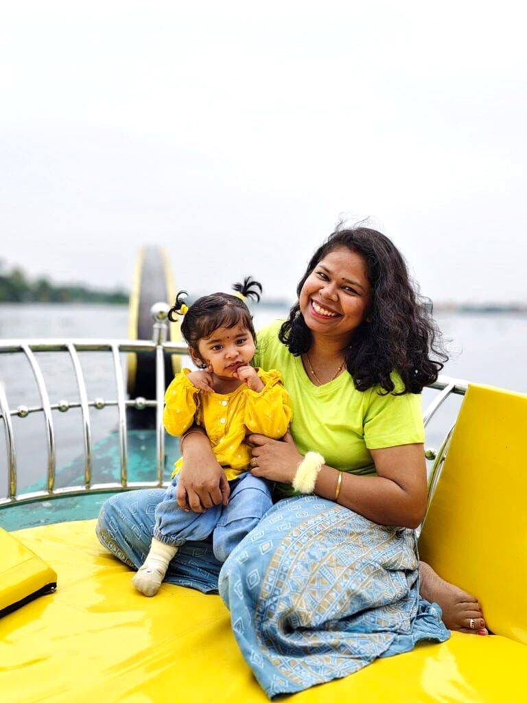 Mother and child sharing a cheerful moment while seated on the front deck of a shikara boat