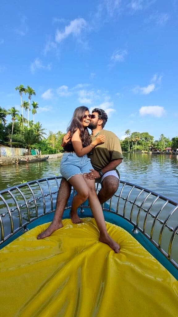 Couple enjoying a private romantic cruise on the front of a shikara boat along quiet village waterways