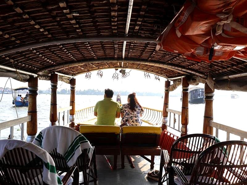 Interior perspective through the handcrafted bamboo ceiling and cane chairs towards the open boat bow
