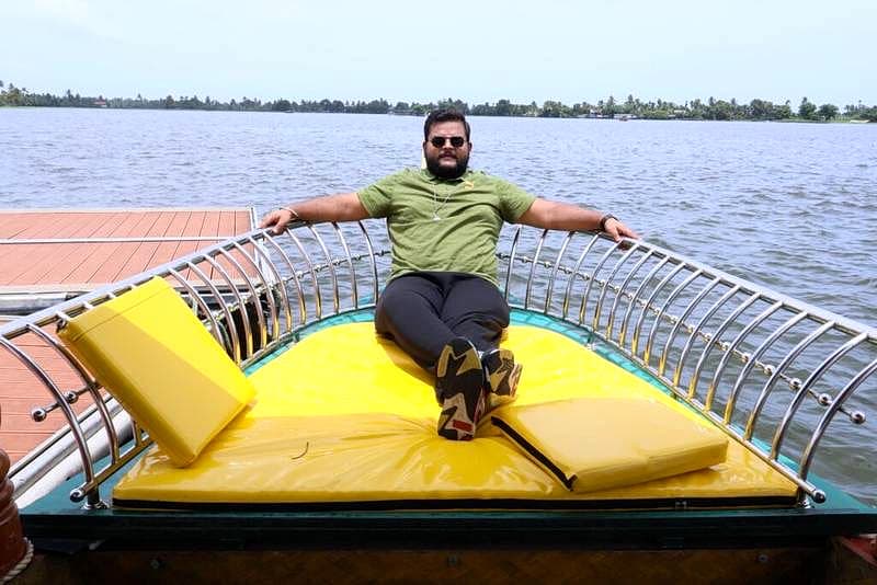 Guest relaxing on the spacious shaded sun deck cushions of a shikara boat in Vazhicherry